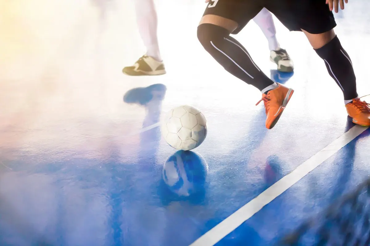 Foto pemain futsal pro lengkap dengan sepatu bermain di dalam ruangan