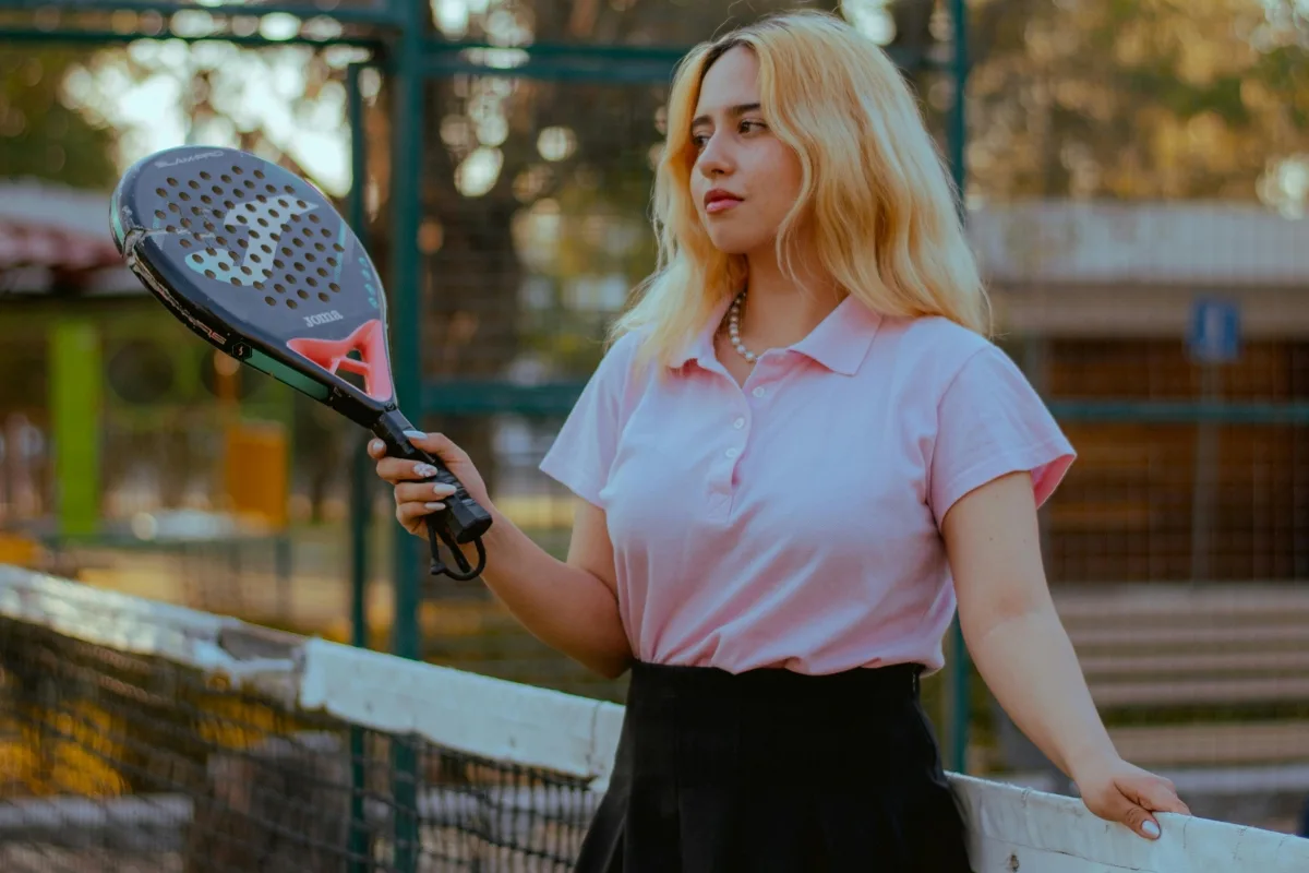 Wanita gadis Indonesia berpakaian rapi memegang raket padel